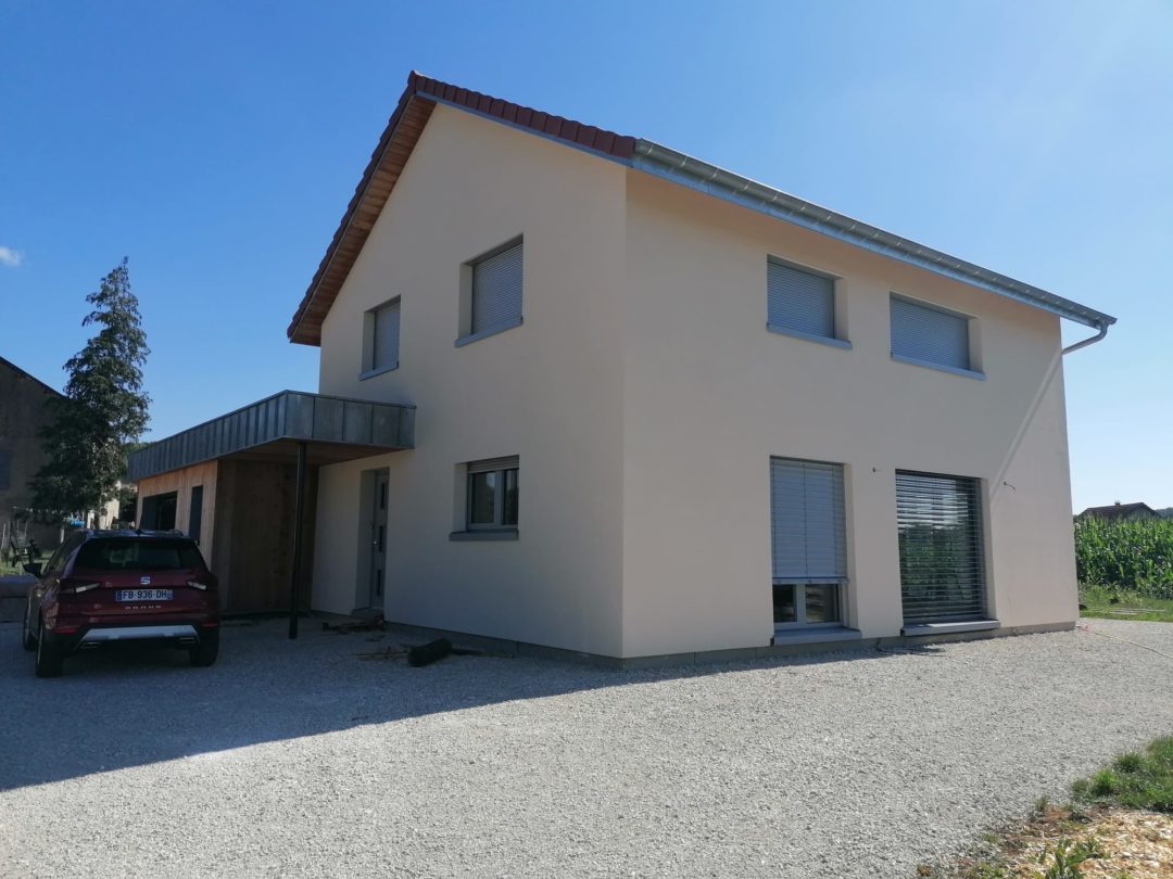 Vue d'ensemble d'une maison avec fenêtres Caméléwood bois alu triple vitrage, maison passive à Sorans