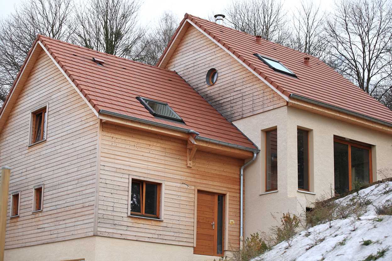 Fenêtres bois double vitrage sur mesure Gamme "confort" Fenêtres bois double vitrage sur mesure Vue d'une maison construite durablement