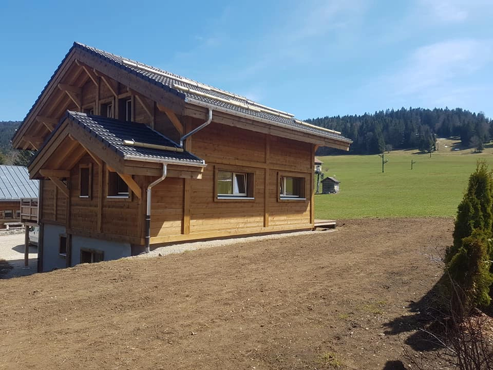 Pose de Fenetres écologique en bois double vitrage dans le Doubs - Maison ossature bois - vue de la maison et de la vallée